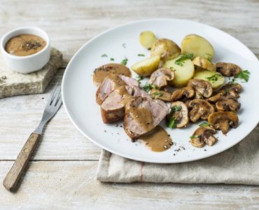 Varkenshaasje met aardappel in de schil en champignons